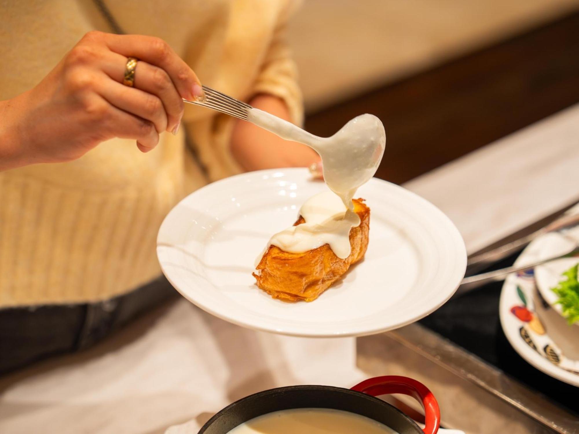 Urayasu Brighton Hotel Tokyo Bay Zewnętrze zdjęcie A woman using a spoon to spread mayonnaise on a piece of bread